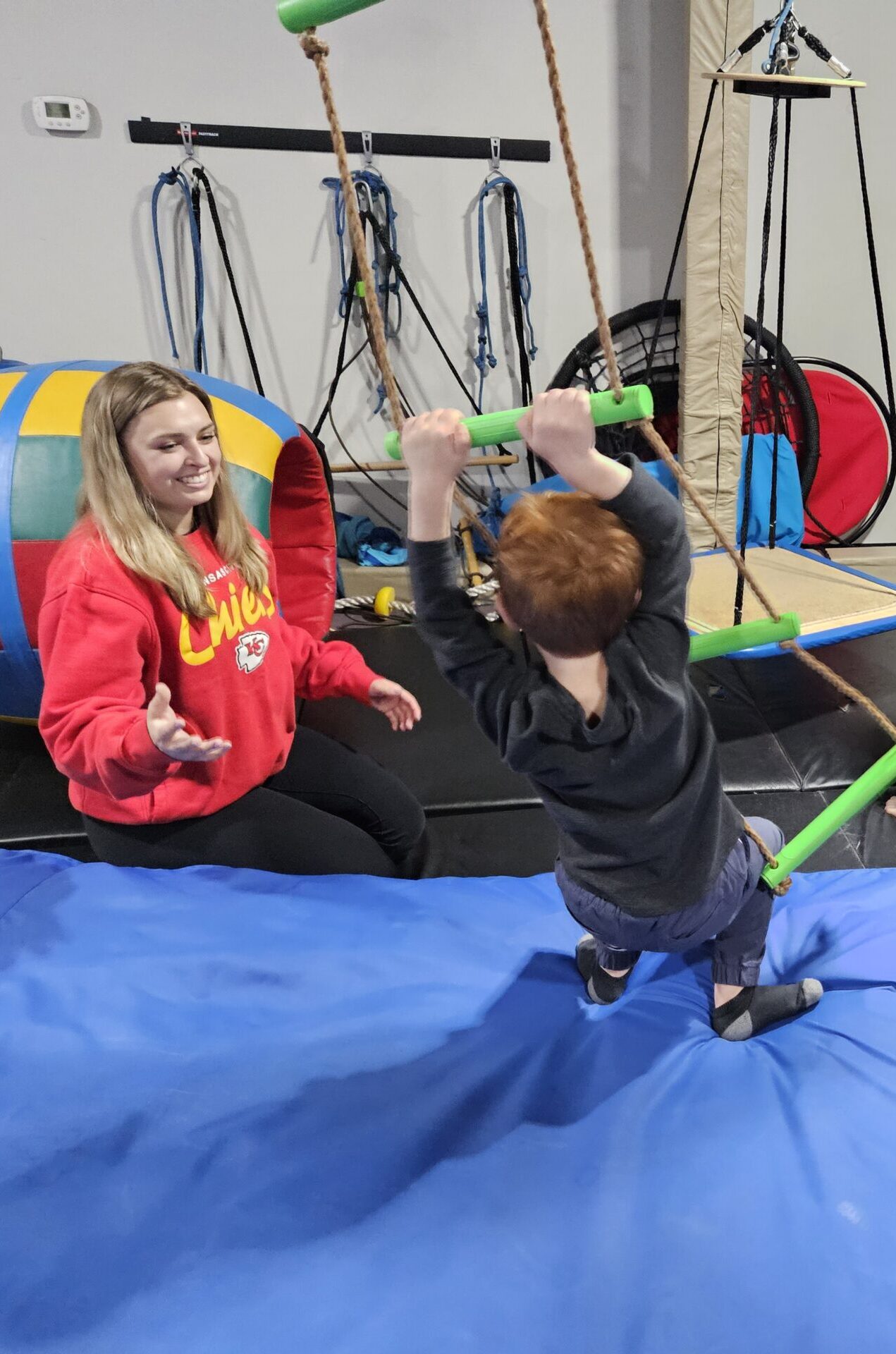 Occupational therapist assists a friend at Step Forward Therapy during a session, as the friend points to her ear, highlighting the focus on body awareness and communication skills development.